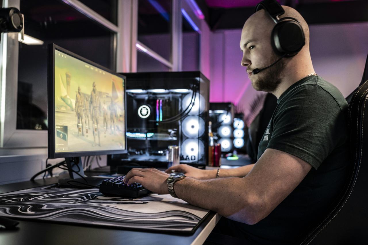 A man sitting in front of a computer with headphones on