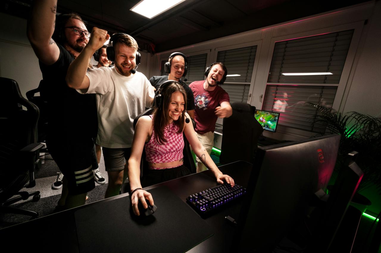 A group of people standing around a computer