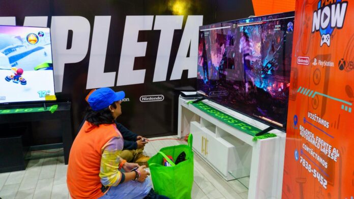 Two people playing video games on a large screen.